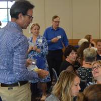 Some alumni sitting, other alumni are walking to find a seat